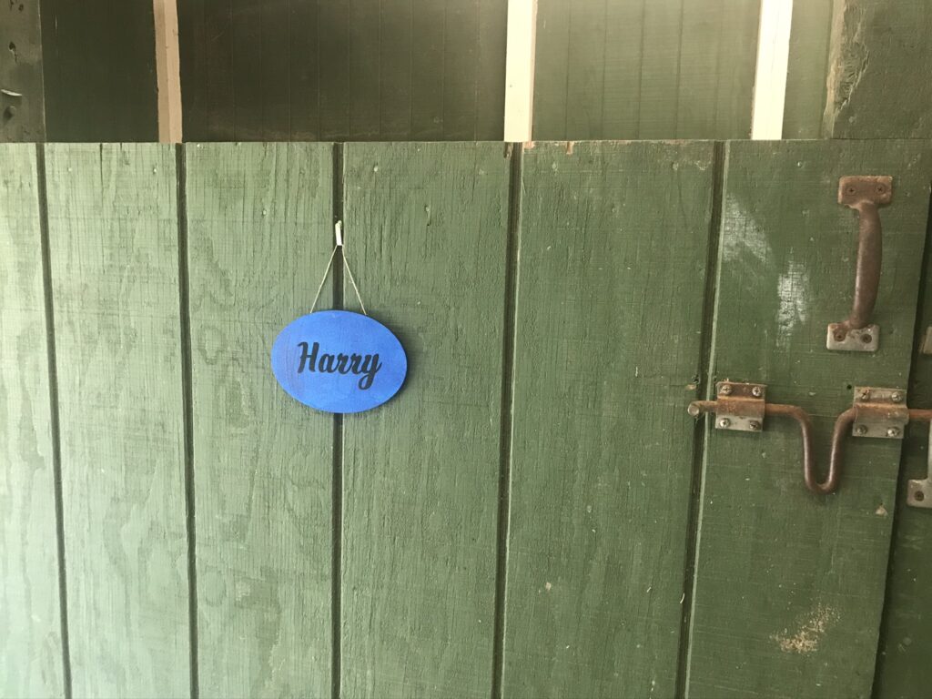 name plate hanging on horse stall door